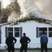 Firefighters quickly get off the roof of a mobile home on fire in the 1515 block of Ridge Road in Superior Township on Tuesday. Daniel Brenner I AnnArbor.com